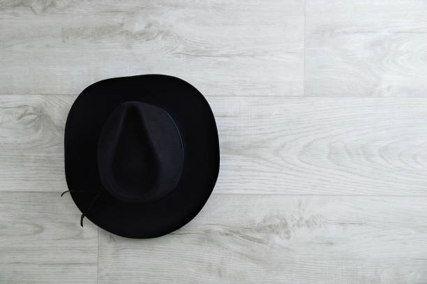 istock Black cowboy hat on gray wooden background. Place for text. 1272777662