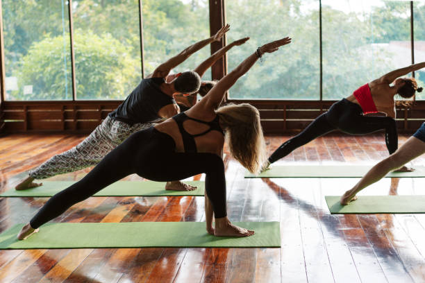 istock Unrecognizable people stretching body during yoga lesson 1272778316