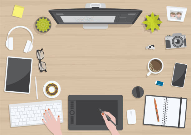 Woman hands graphic designing on wood table top view Wood textured table from top view with hands of woman drawing on digital graphic tablet with monitor, camera, tablet, headphones and gadgets, design for work from home concept wooden flash drive stock illustrations