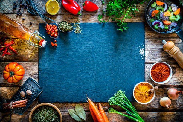 istock Multi colored vegetables and spices border on rustic wooden table. Copy space 1272783672
