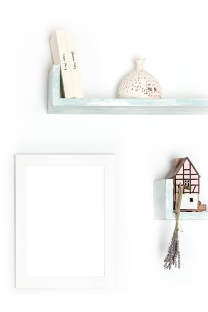 istock Poster mock-up. A blank frame on a wall with books and objects 1272785058
