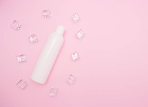istock White plastic bottle for shampoo or other cosmetics. Ice cubes around, pink background, free space for text, top view. 1272785168