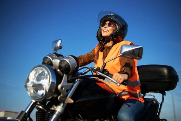 istock Motorcycle riding school and courses. Student with helmet and reflective vest riding motorcycle on class. 1272787326