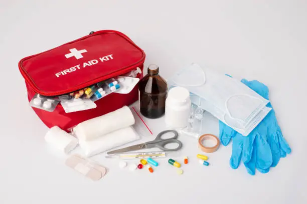 First aid kit on white table.