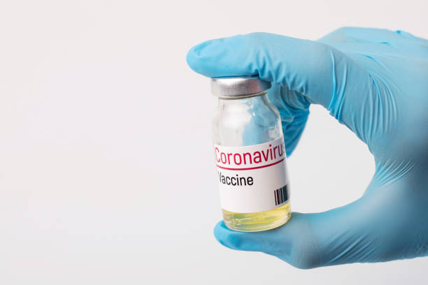 istock Doctor holds coronavirus vaccine before injection. 1272787612