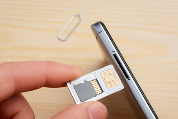 istock Man inserting tray for SIM card and memory drive to the mobile phone 1272787973