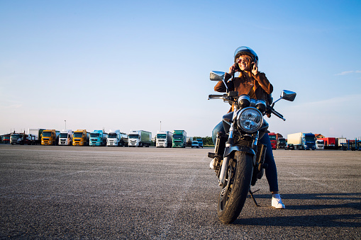 Hermosa mujer morena sexy en chaqueta de cuero sentado en la motocicleta de estilo retro preparándose para el paseo. Montar en moto. Copie el espacio para el texto proporcionado. photo