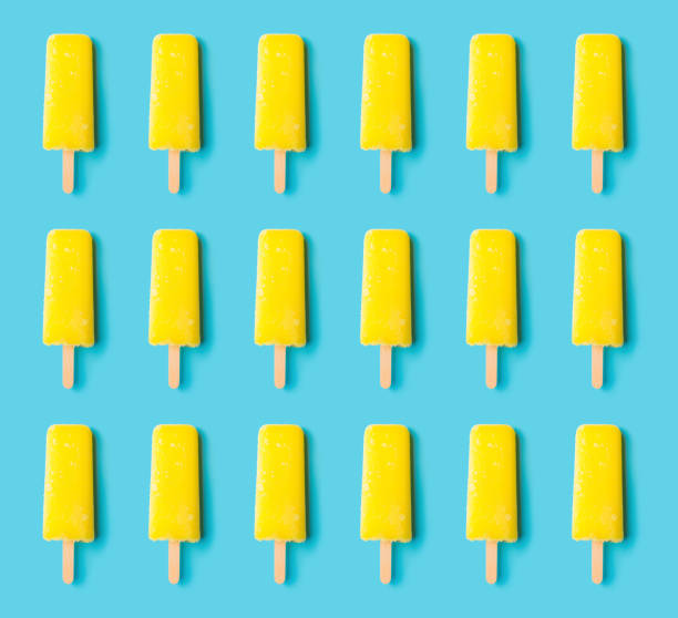 istock seamless background of yellow popsicle on blue 1272788553