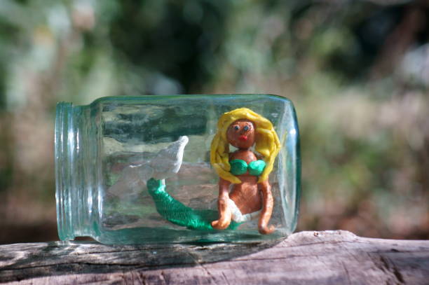 figura de sirena hecha de plasticina en un frasco de vidrio. - mala de la sirenita fotografías e imágenes de stock