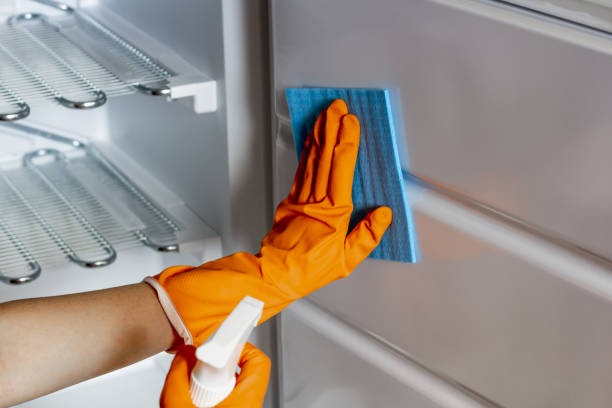 istock Female hand in protective gloves are wiping refrigerator inside 1272797442