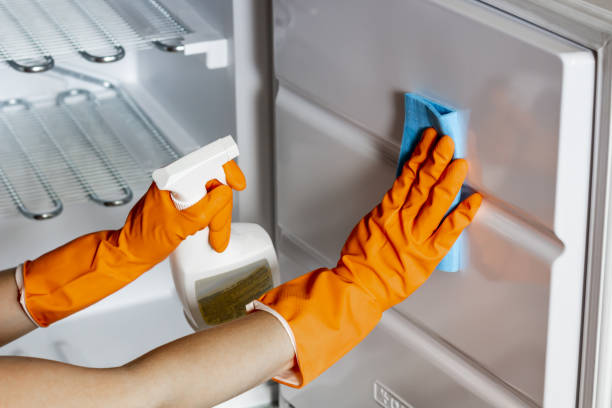 istock Female hands in protective gloves are wiping refrigerator inside 1272797443