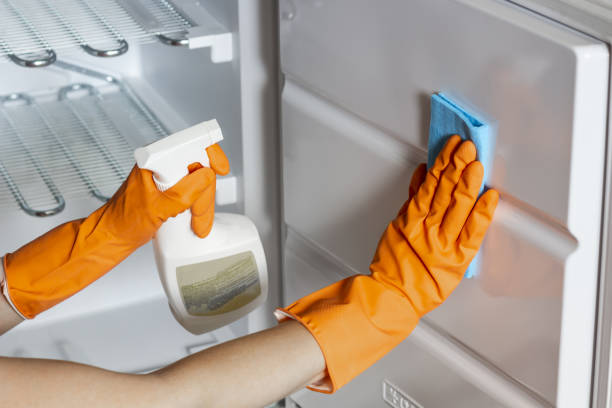 istock Female hands in protective gloves are wiping refrigerator inside 1272797445