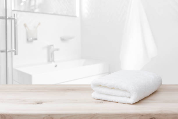 istock White towel with space on wood and blurred bathroom interior 1272798376
