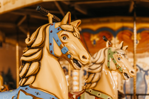 Childrens attraction of colorful carousel in traditional style with horse closeup, holiday, Christmas market, selective focus