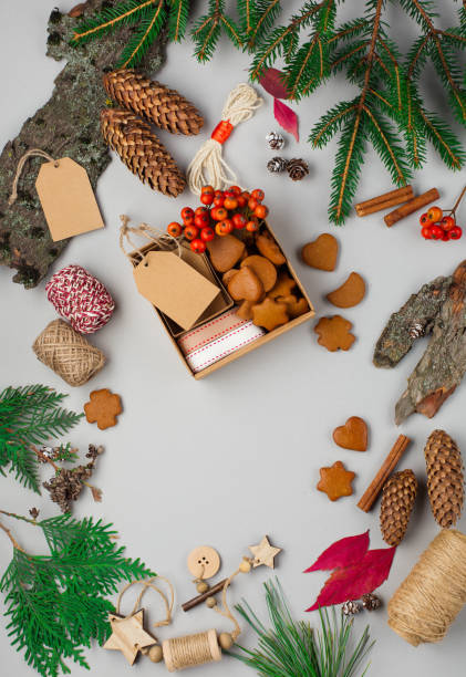 istock Hand crafted gift on gray background with Christmas decorations and gingerbread cookies. Flat lay, top view. 1272799712