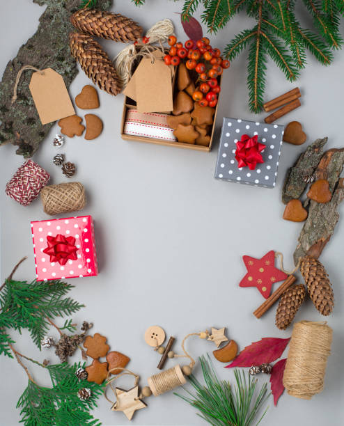 istock Hand crafted gift on gray background with Christmas decorations and gingerbread cookies. Flat lay, top view. 1272799725
