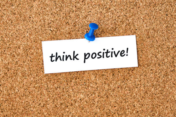 istock Think positive. Text written on a piece of paper, cork board background. 1272800349