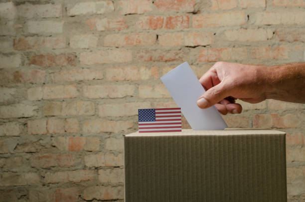 istock Man voting and putting bulletin into the box.Empty space 1272801558