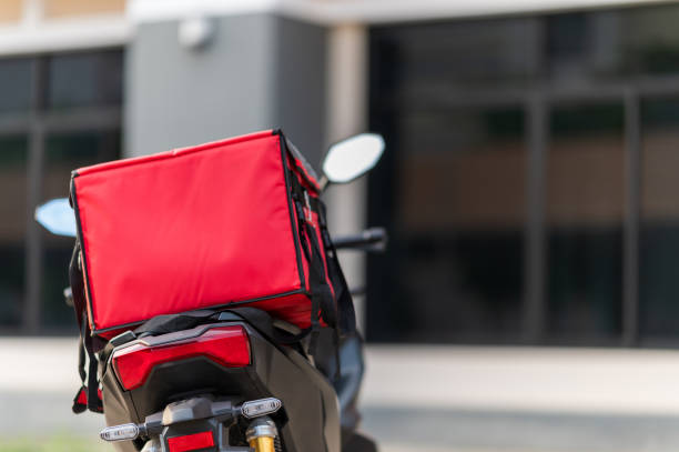 A red box is placed on the motorbike to deliver the product to the customer. A red box is placed on the motorbike to deliver the product to the customer. Delivery Driver stock pictures, royalty-free photos & images