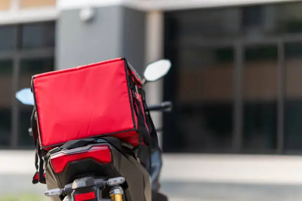 Photo of A red box is placed on the motorbike to deliver the product to the customer.