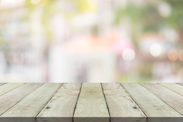 istock Empty wood table top on green blur background at shopping mall 1272803236