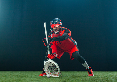 Lacrosse Player, athlete sportsman in red helmet on dark background. Sport and motivation wallpaper
