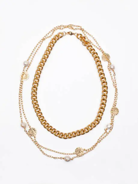 Photo of Two women`s gold necklaces on white background