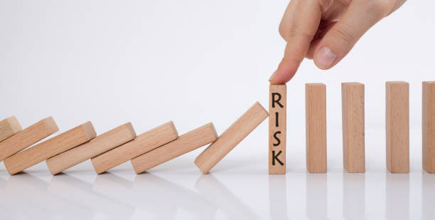 istock domino effect and risk management concept. manager stops falling wooden cubes with his finger. 1272805554