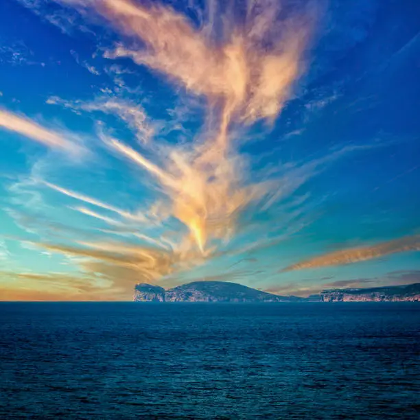 view of the coast of capo caccia with dramatic csky at sunset