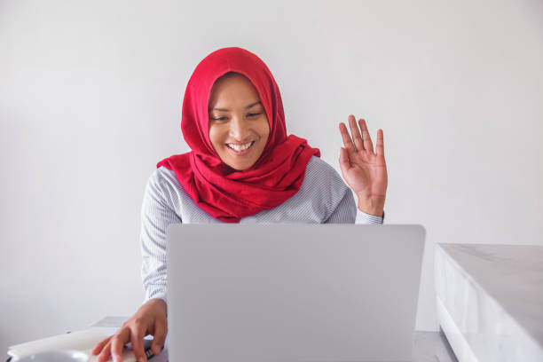 istock Happy Southeast Asian teacher greeting her students on web conference 1272807916