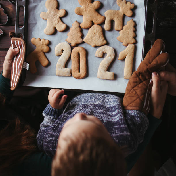 ジンジャーブレッドクッキーを持つ小さな男の子と両親 - cookie mother 30s parent ストックフォトと画像