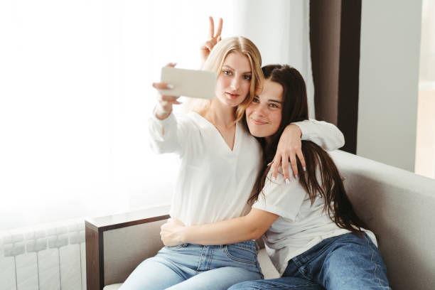 istock Two friends making selfie cuddling and embracing 1272808463