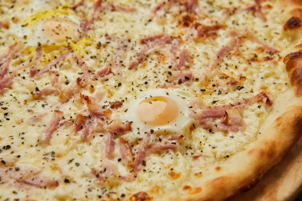 istock Delicious Italian Pizza Carbonara with Bacon, eggs and mozzarella cheese on dark background 1272812391