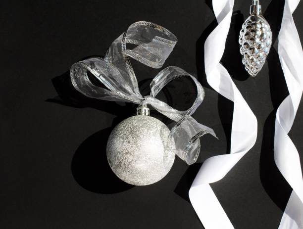 istock silver christmas decorations, white ribbons on black background 1272815297