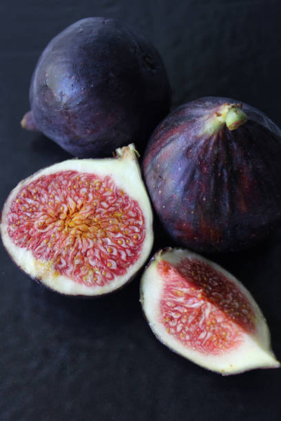 istock Purple Fig slices on a dark background close-up.Texture or background 1272817107