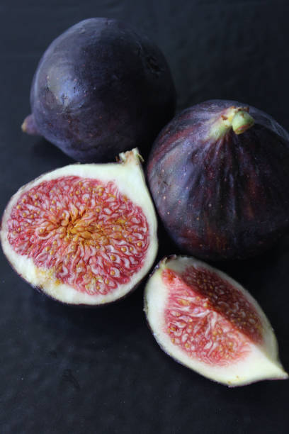 istock Juicy Fig slices on a dark background close-up.Texture or background 1272817158
