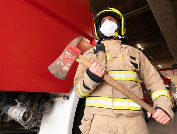 istock Firefighter holds ax equipped with intervention equipment, helmet and mask, to protect himself from the covid 19. 1272817178