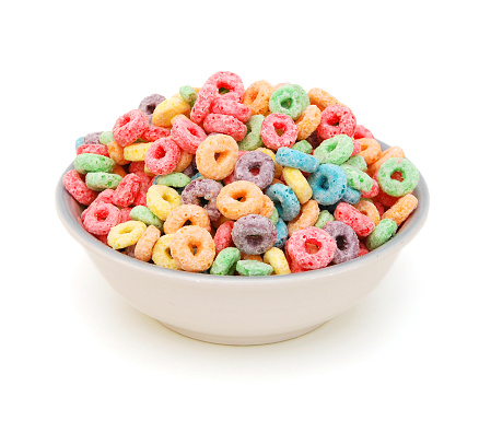 Deliciosos y nutritivos bucles de cereales de frutas sabrosos sobre fondo blanco, adición saludable y divertida al desayuno de los niños photo