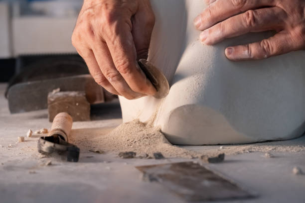 Carving the clay with pottery tools
