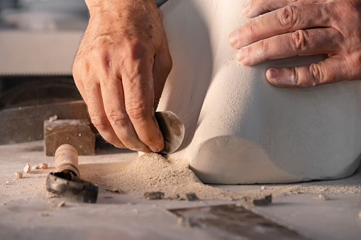 Carving the clay with pottery tools
