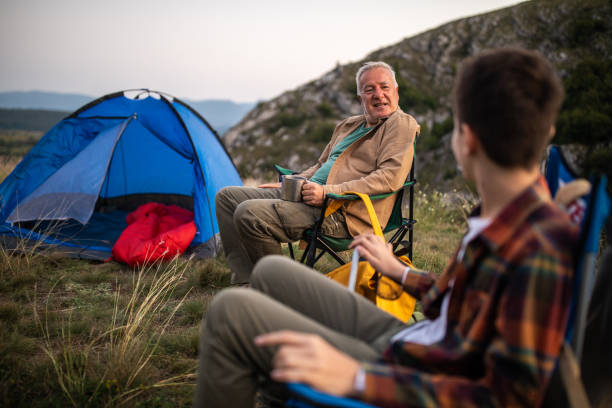 family enjoying quality time together during camping on mountain - camping tent offspring 60s imagens e fotografias de stock