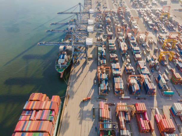istock DRONE AERIAL Logistics and transportation of Container Cargo ship and Cargo plane with working crane bridge in shipyard at sunrise, logistic import export and transport industry background 1272822663