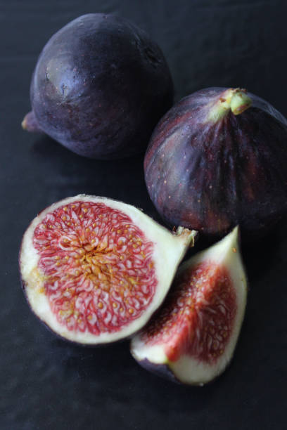 istock Purple Fig slices in close-up on a dark background 1272822802