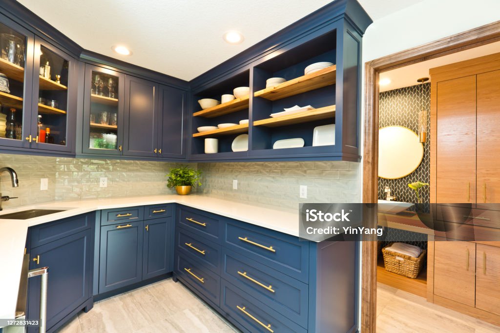 Remodeled Contemporary Bar Pantry Room A contemporary bar kitchen pantry room renovation remodeling featuring wine storage cabinet, bar sink and various pantry storage and adjoining bathroom. Bathroom Stock Photo