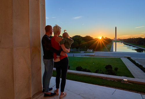 Couple and Their Toddler Daughter  at the Lincoln Memorial with the Washington Memorial in the Background at Sunrise in Washington DC Capital of the USA
