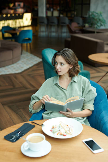 istock Displeased young bearded man sitting in modern cafe and waiting for answer while calling by cellphone 1272834140