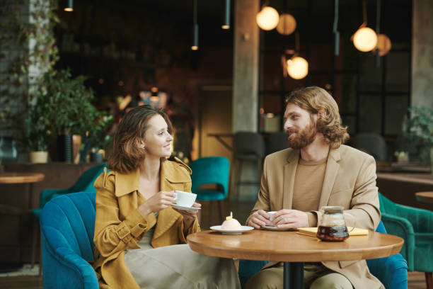 istock Pensive young bearded SMM manager drinking coffee and thinking about customers message while working remotely in cafe 1272835705