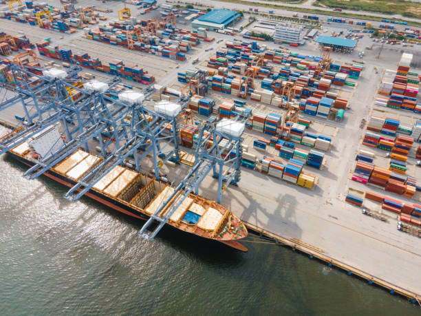 istock Drone point of view Logistics and import,export Container Cargo ship in asia working for e-commerce business Shot by drone crane bridge in shipyard at sunset , logistic import export and transport industry background 1272839203