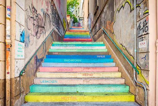 Wuppertal, Germany - September 6, 2020: The Holstein staircase in Wuppertal, Germany. The staircase with 112 steps dates from 1900. In 2006, artist Horst Gläsker converted the Holstein staircase into an installation. He interpreted the nine sections of the staircase as nine sections of life and painted each of the 112 steps in a different color to represent the path of life. Words are written on the front side that can only be read when climbing the mountain. The words contain simple terms and are sorted according to their meaning, such as 