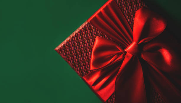 istock Red gift boxes on green background. Christmas card. Flat lay. Top view with space for text. 1272841432